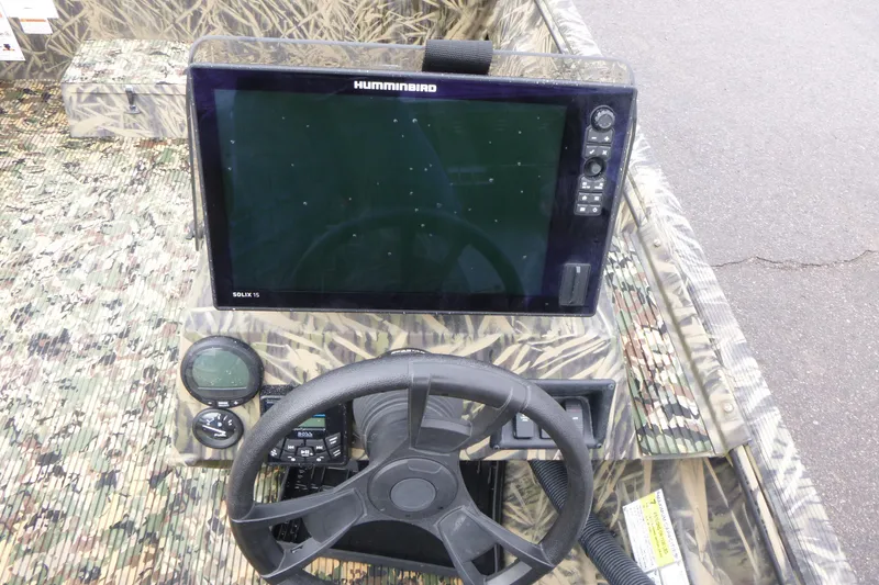 Slide: The Image of 2024 Lowe Roughneck 2070 boat dashboard with Humminbird Solix 15 display and camo design. - 26