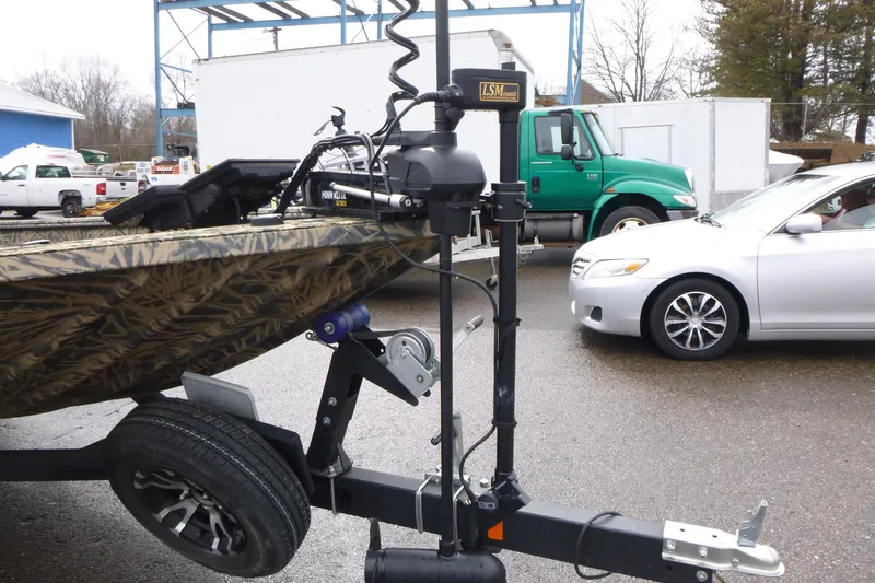 Slide: The Image of 2024 Lowe Roughneck 2070 boat on trailer, featuring a mounted trolling motor. - 28