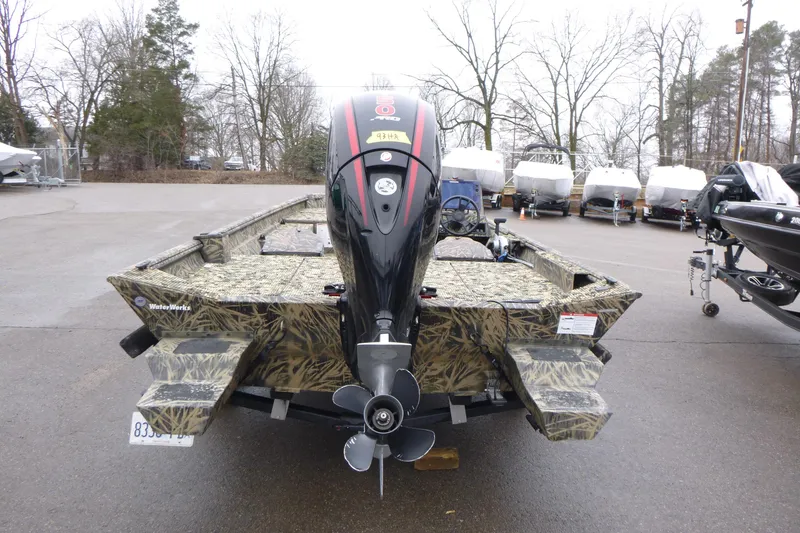 Slide: The Image of 2024 Lowe Roughneck 2070 boat with camouflage design and outboard motor in a parking lot. - 4