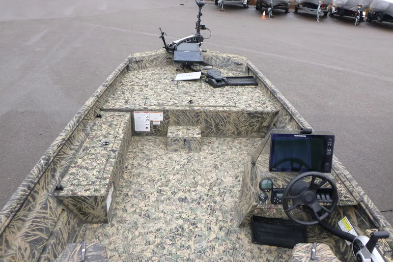 Slide: The Image of 2024 Lowe Roughneck 2070 boat interior with camouflage design and modern controls. - 6