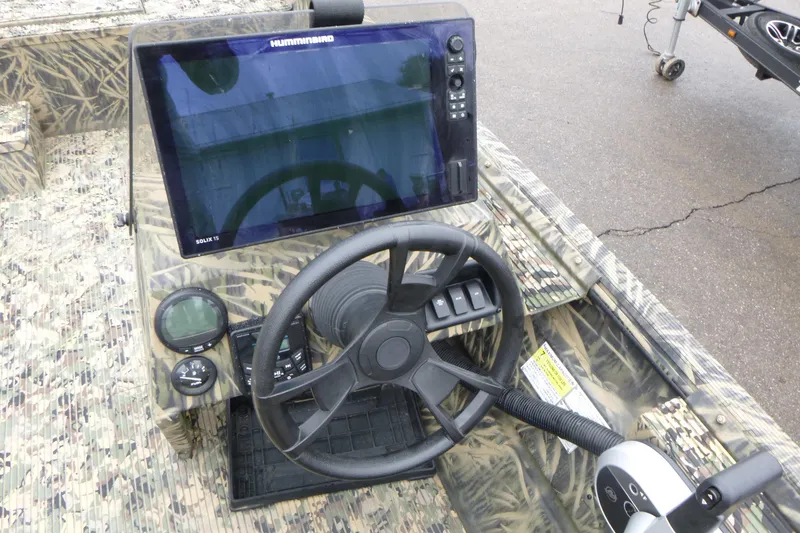 Slide: The Image of 2024 Lowe Roughneck 2070 boat dashboard with steering wheel and Humminbird Solix 15 display. - 7