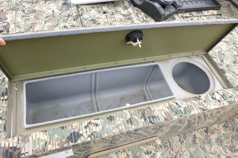 Slide: The Image of Open storage compartment on 2024 Lowe Roughneck 2070 boat with camouflage design. - 9