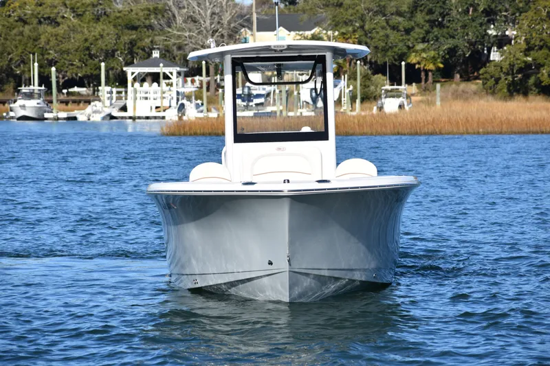 Slide: The Image of 2020 Sea Hunt Ultra 255 SE boat on calm water, marina in background. - 1