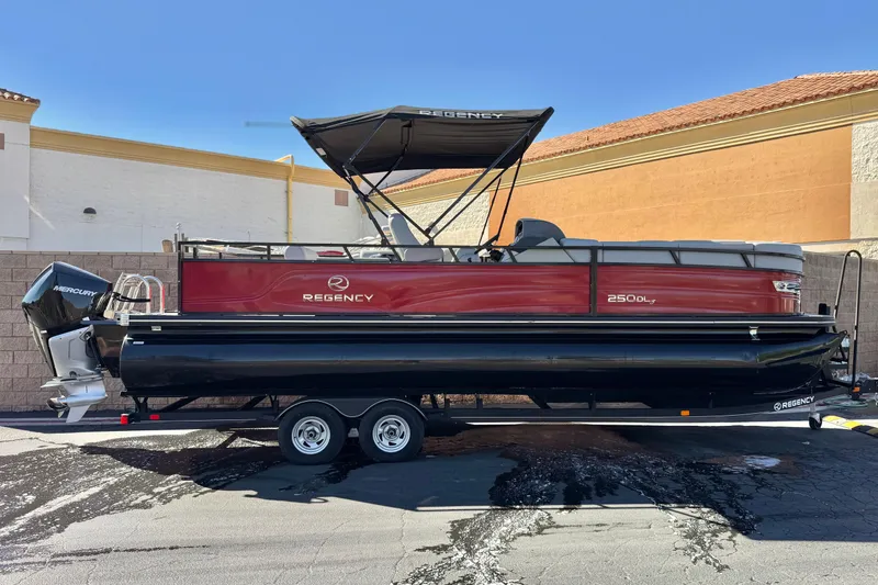 The Image of 2023 Regency 250 DL3 pontoon boat on trailer, parked outdoors. - 0