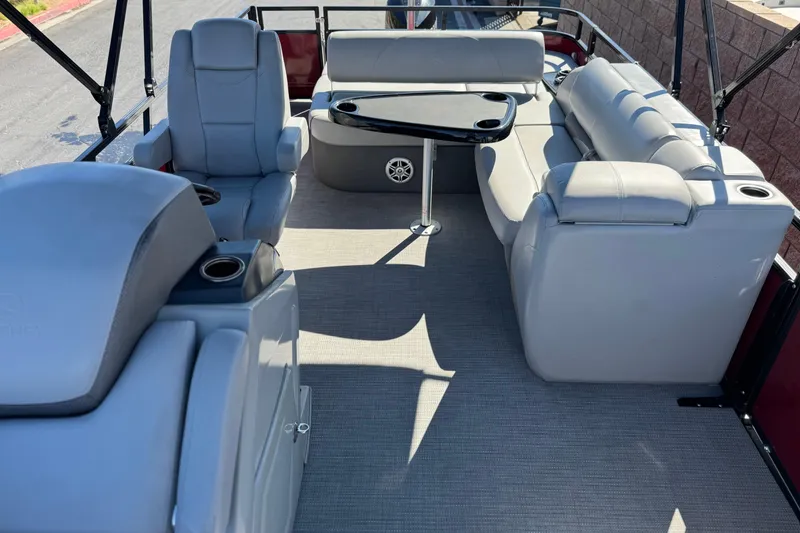 Slide: The Image of Luxurious seating area on 2023 Regency 250 DL3 pontoon boat with table and cup holders. - 15