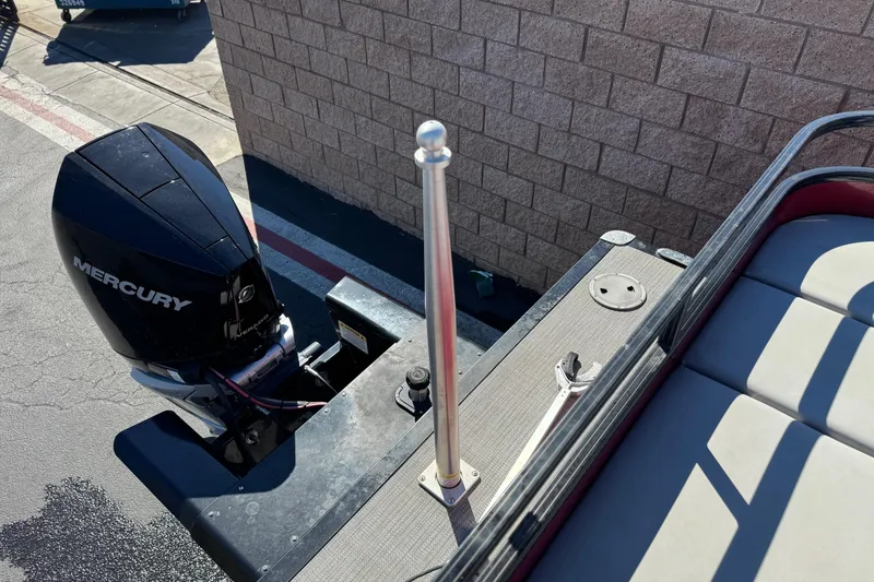 Slide: The Image of 2023 Regency 250 DL3 boat with Mercury outboard motor, docked near a brick wall. - 26