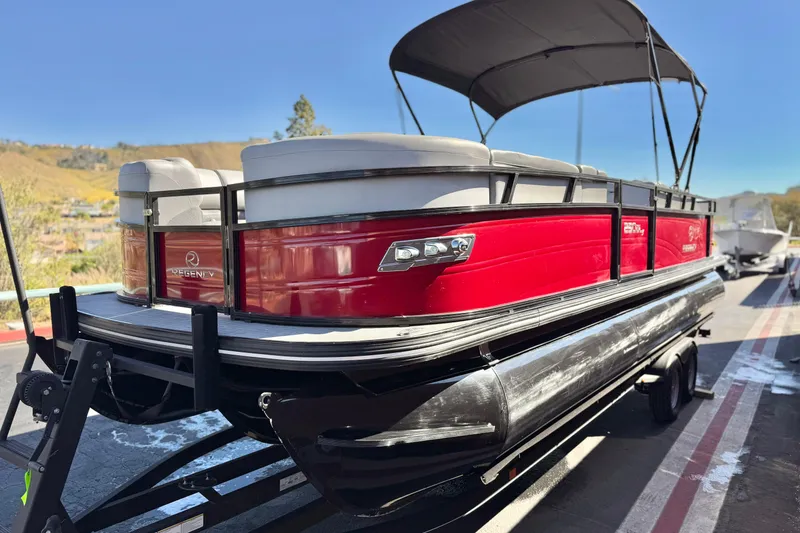 Slide: The Image of 2023 Regency 250 DL3 pontoon boat with red exterior on a trailer. - 3