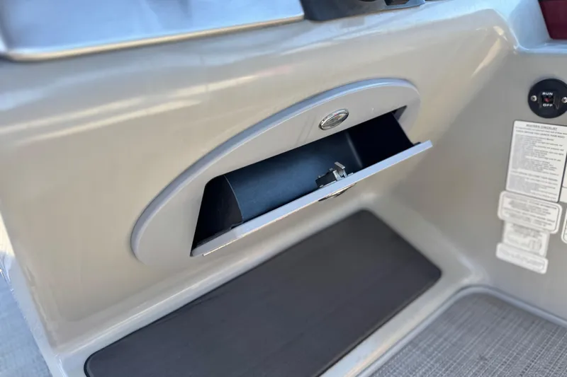 Slide: The Image of Open storage compartment on 2023 Regency 250 DL3 boat dashboard. - 31