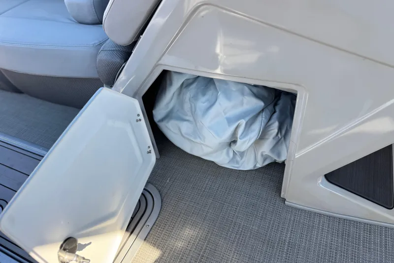 Slide: The Image of Open storage compartment on 2023 Regency 250 DL3 boat with fabric inside. - 33