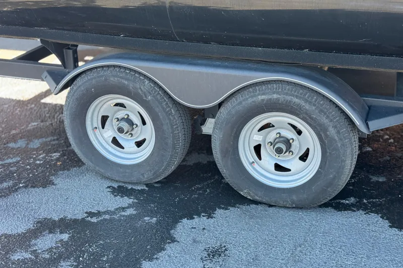 Slide: The Image of Trailer wheels of a 2023 Regency 250 DL3 on asphalt surface. - 34