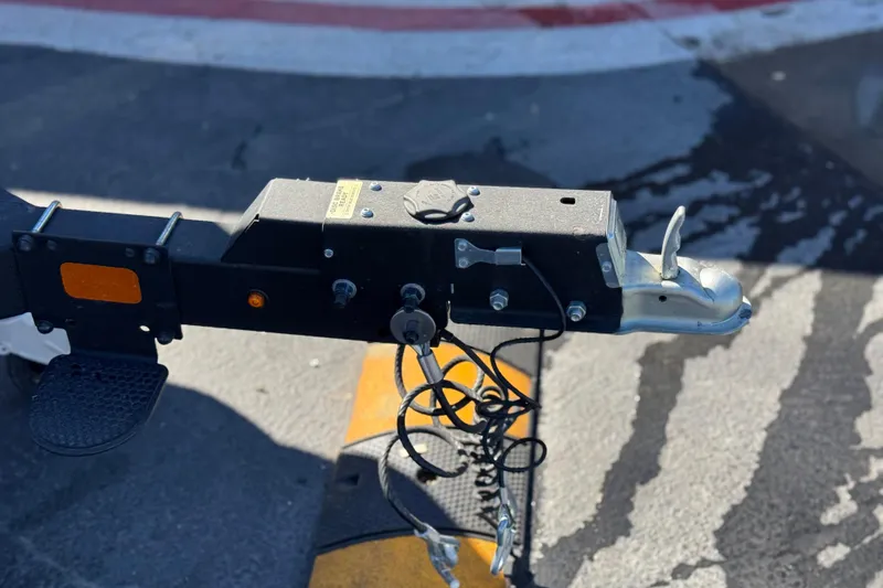 Slide: The Image of Trailer hitch of a 2023 Regency 250 DL3 boat, parked on asphalt. - 35