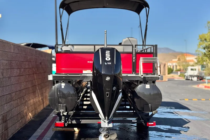 Slide: The Image of 2023 Regency 250 DL3 pontoon boat with powerful V8 engine, parked outdoors. - 5