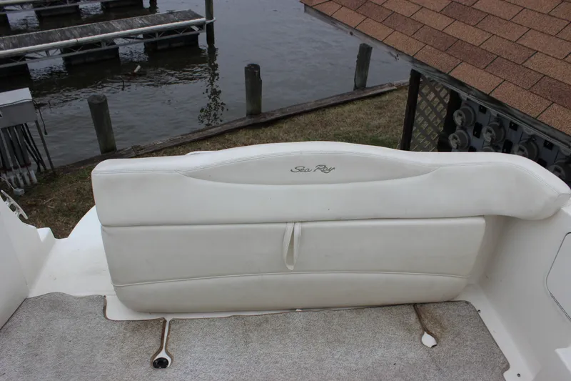 Slide: The Image of White leather seating on a 2005 Sea Ray Sundancer 280 boat near a dock. - 12
