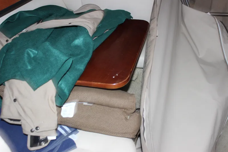 Slide: The Image of Interior of 2005 Sea Ray Sundancer 280 with table and folded clothing. - 13