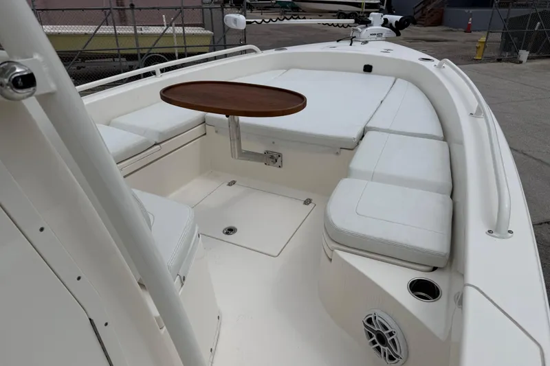 Slide: The Image of 2023 Pathfinder 2600 TRS boat interior with cushioned seating and a wooden table. - 14