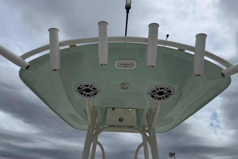 Slide: The Image of 2023 Pathfinder 2600 TRS boat top view with rod holders and speakers against cloudy sky. - 8