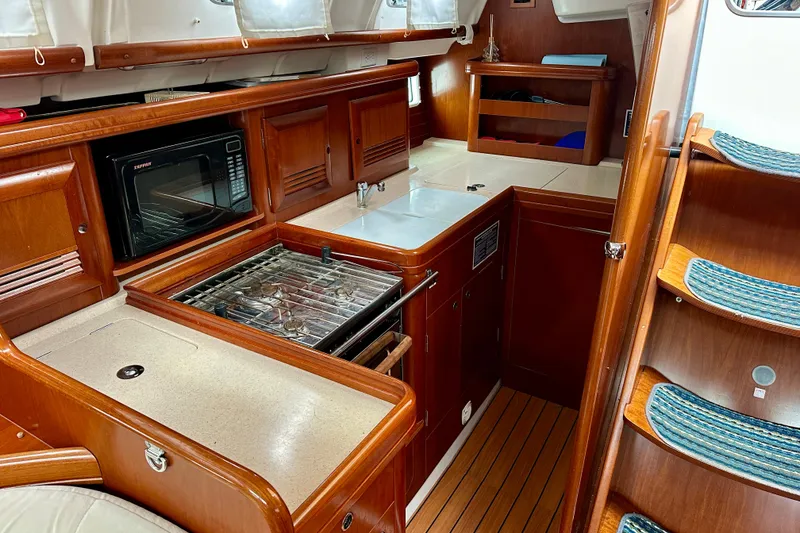 Slide: The Image of Interior of 2005 Beneteau Oceanis Clipper 423 yacht with wooden cabinetry and kitchen amenities. - 18