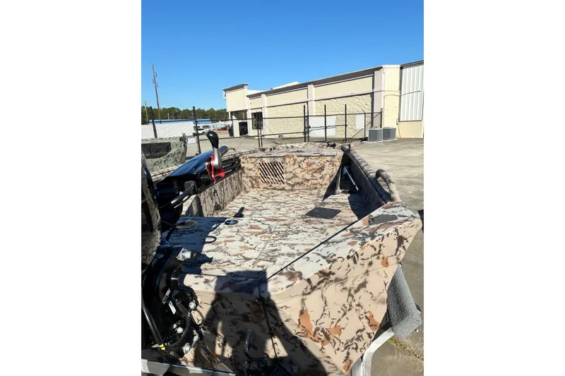 Slide: The Image of 2025 Excel Eclipse boat with camouflage interior, parked outdoors under clear blue sky. - 4