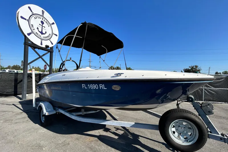 The Image of 2017 Bayliner Element E16 boat on trailer under clear blue sky. - 0