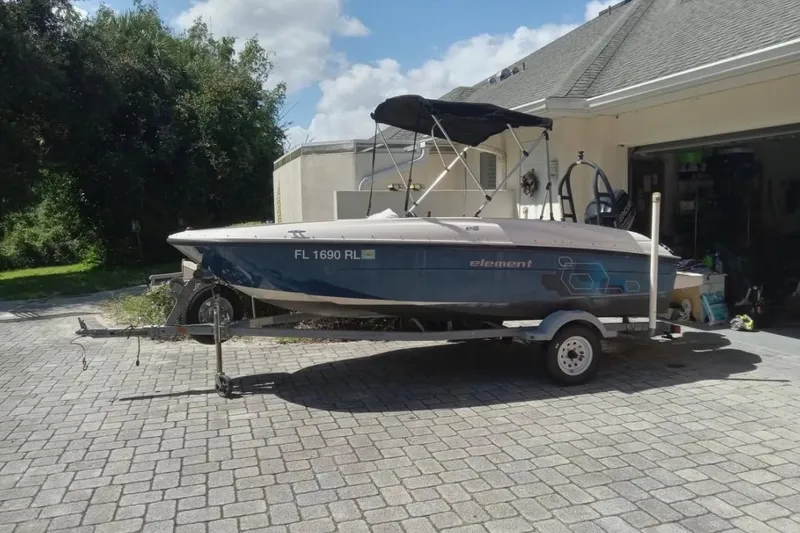 The Image of 2017 Bayliner Element E16 boat on trailer in driveway, sunny day. - 1
