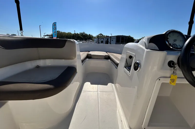 Slide: The Image of 2017 Bayliner Element E16 boat interior with seating and dashboard under clear blue sky. - 18