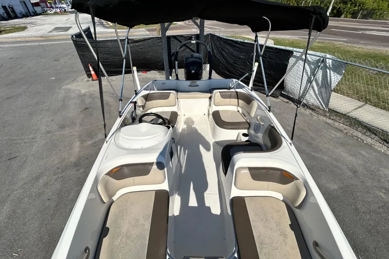 Slide: The Image of 2017 Bayliner Element E16 boat with seating and canopy, parked on pavement. - 26