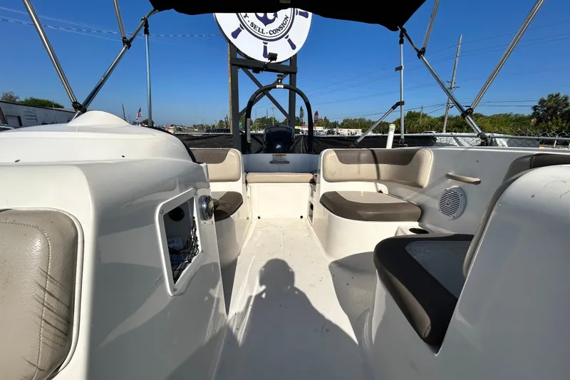 Slide: The Image of 2017 Bayliner Element E16 boat interior with seating and canopy under clear blue sky. - 28