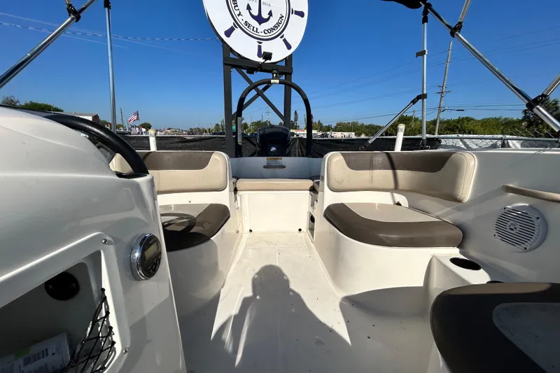 Slide: The Image of 2017 Bayliner Element E16 boat interior with seating and steering wheel under clear blue sky. - 29