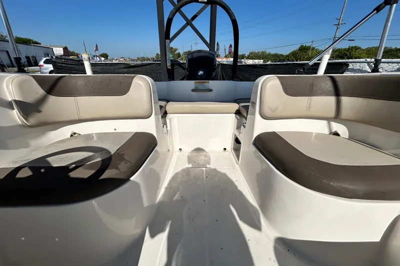 Slide: The Image of 2017 Bayliner Element E16 boat interior with seating and steering wheel under clear blue sky. - 30
