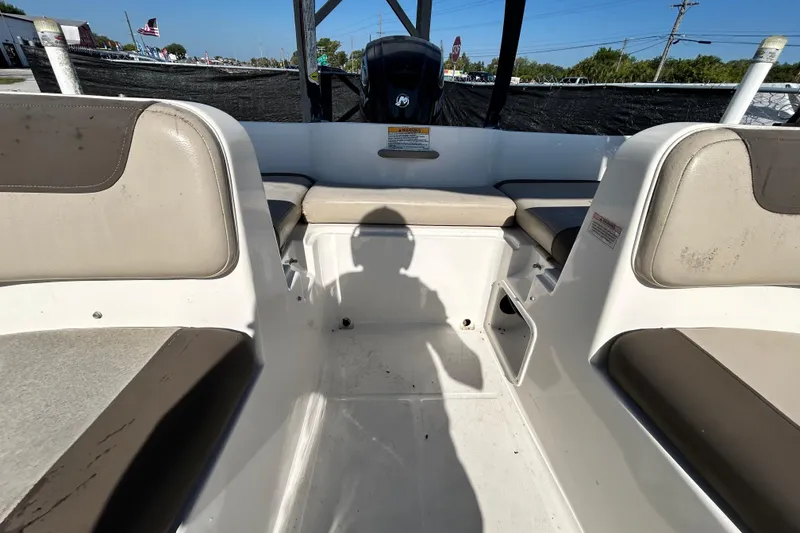 Slide: The Image of 2017 Bayliner Element E16 boat interior with seating and motor, under sunny skies. - 31