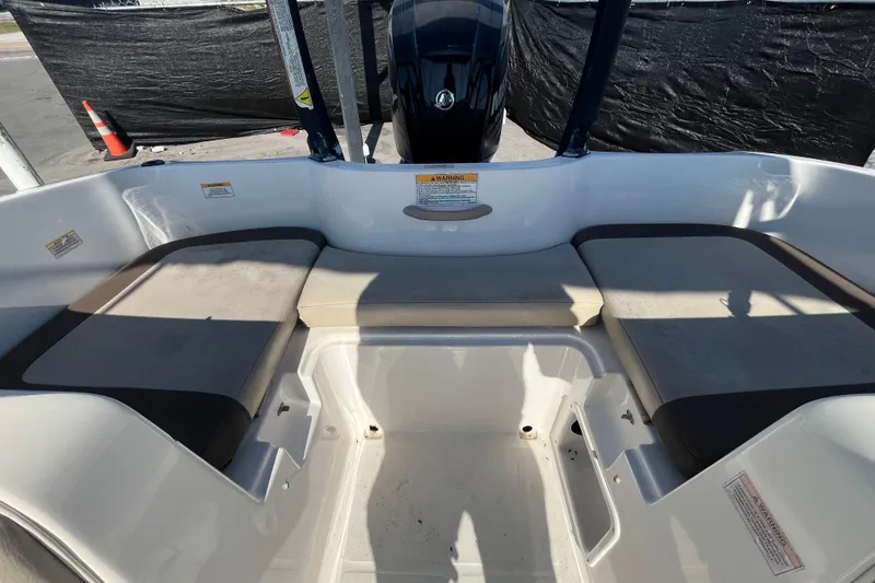 Slide: The Image of 2017 Bayliner Element E16 boat interior with cushioned seating and motor view. - 34