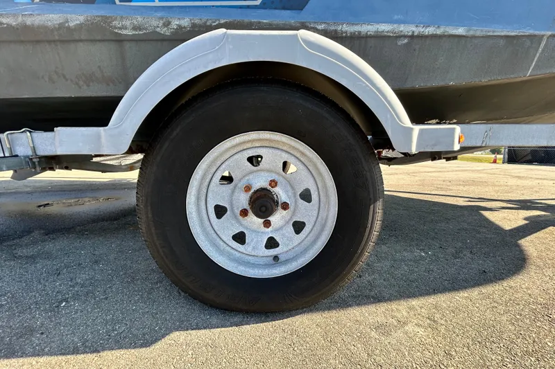 Slide: The Image of Trailer wheel of a 2017 Bayliner Element E16 boat on pavement. - 45