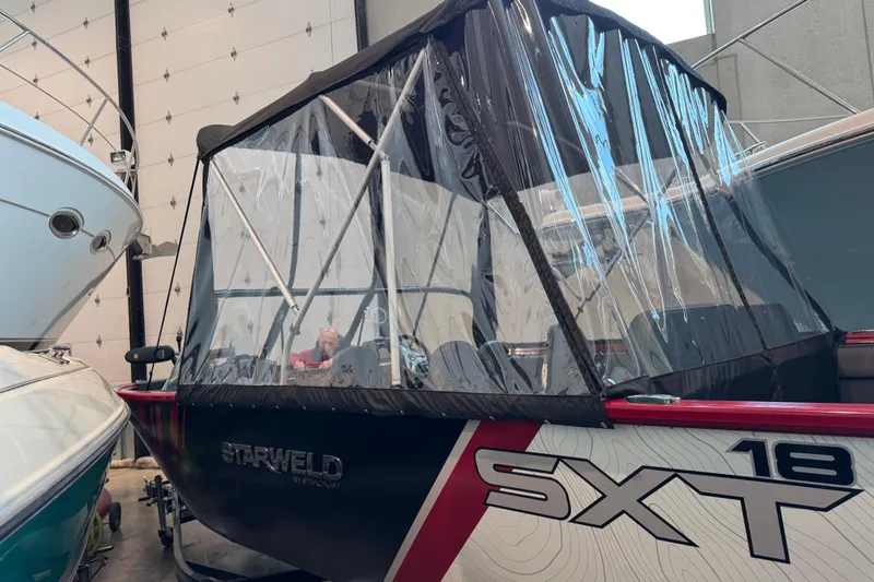 Slide: The Image of 2026 Starweld 18 SXT boat with protective canopy in storage. - 7