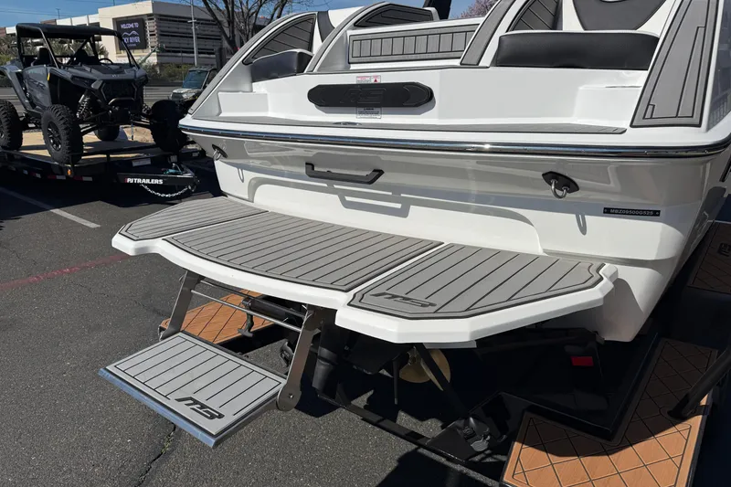 Slide: The Image of 2025 MB B52 25 Alpha boat with swim platform and step ladder in a parking lot. - 13