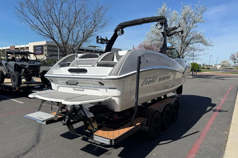 Slide: The Image of 2025 MB B52 25 Alpha boat on trailer in parking lot, clear sky background. - 5