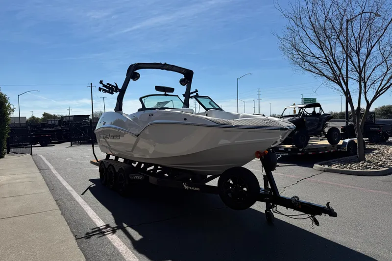 Slide: The Image of 2025 MB B52 25 Alpha boat on trailer in parking lot under clear sky. - 6