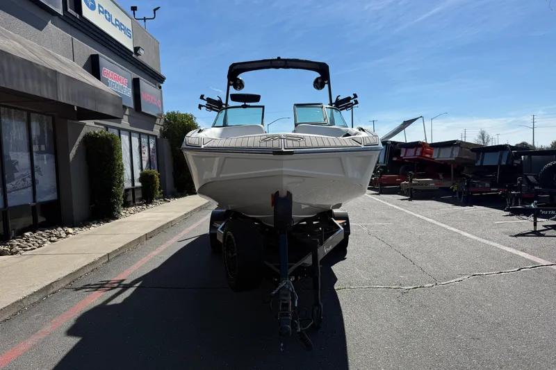 Slide: The Image of 2025 MB B52 25 Alpha boat on trailer outside dealership, sunny day. - 7
