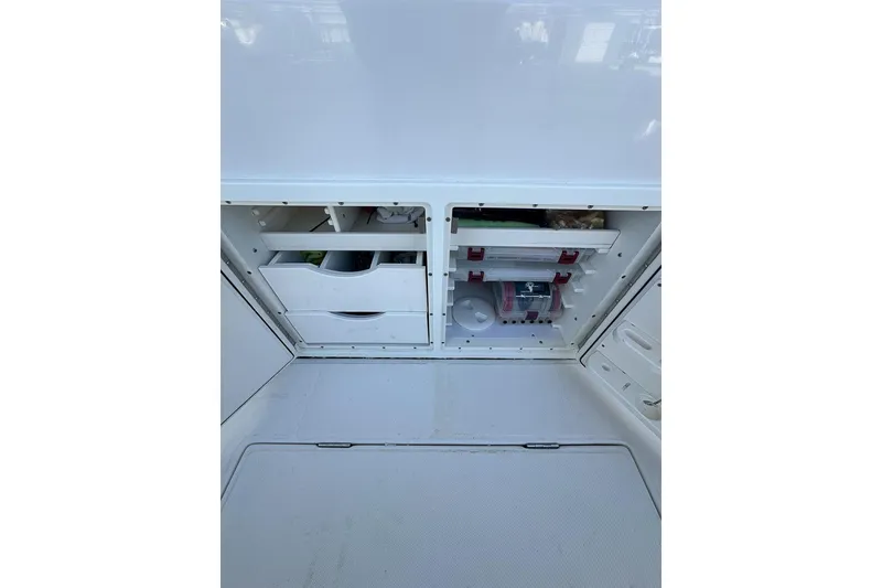 Slide: The Image of Storage compartments on a 2018 Jupiter 26 FS boat, featuring organized drawers and shelves. - 16