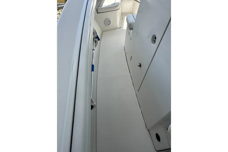 Slide: The Image of 2018 Jupiter 26 FS boat interior with sleek white design and storage compartments. - 19
