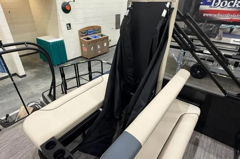 Slide: The Image of 2026 Godfrey Sweetwater 2286 SFLC boat interior with beige seating and black fabric cover. - 20
