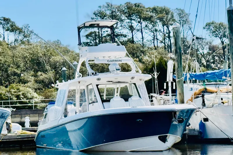 The Image of 2021 Everglades 395 Center Console boat docked, featuring sleek design and advanced Garmin navigation. - 0