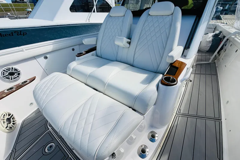 Slide: The Image of Luxurious seating on 2021 Everglades 395 Center Console boat with white upholstery and cup holders. - 10