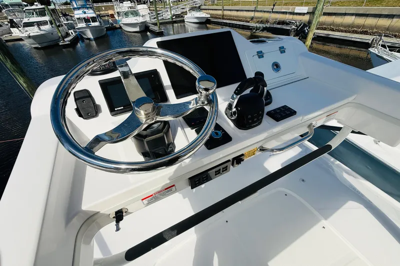 Slide: The Image of 2021 Everglades 395 Center Console helm with steering wheel and controls at marina. - 17
