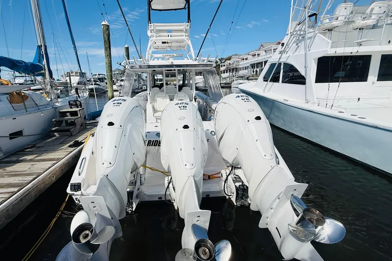 Slide: The Image of 2021 Everglades 395 Center Console boat with triple outboard engines docked at marina. - 18