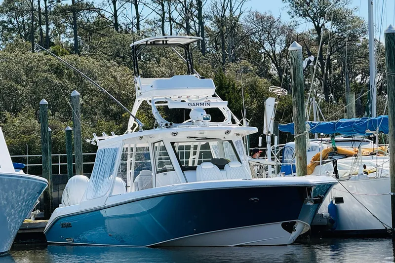 Slide: The Image of 2021 Everglades 395 Center Console boat docked at marina with lush trees in background. - 20