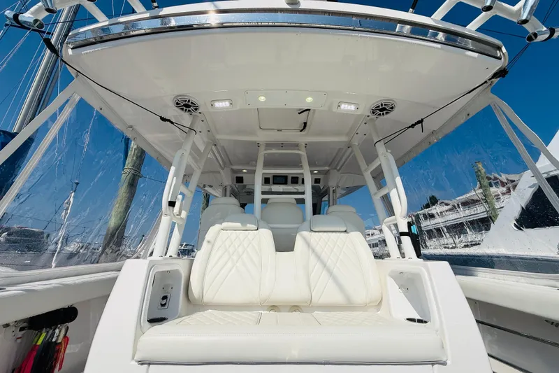 Slide: The Image of 2021 Everglades 395 Center Console boat interior with white seating and clear canopy. - 27