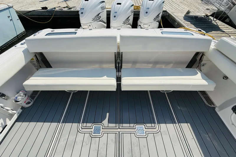 Slide: The Image of 2021 Everglades 395 Center Console boat with foldable seating and triple outboard engines. - 49