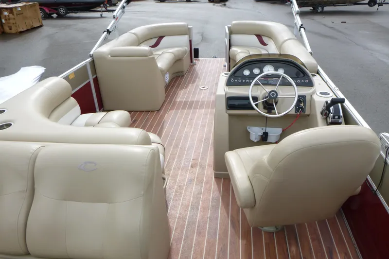 Slide: The Image of Interior of a 2012 Crest 230SLR Classic pontoon boat with beige seating and wood flooring. - 5