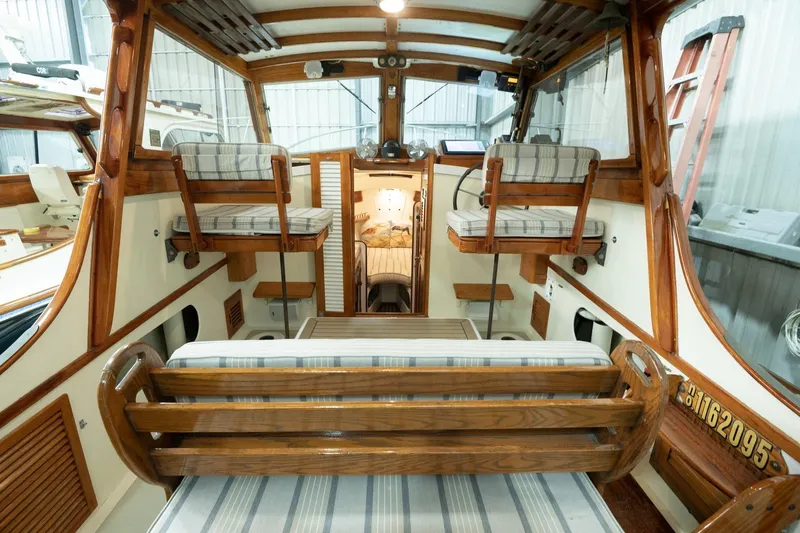 Slide: The Image of 1986 Dyer Hardtop boat interior with wooden seating and striped cushions. - 11