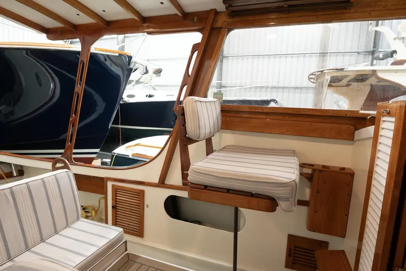Slide: The Image of 1986 Dyer Hardtop boat interior with striped seating and wooden accents. - 16